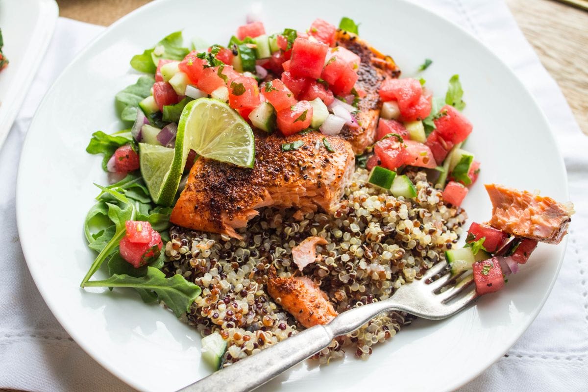 shallow bowl with quinoa, roasted salmon, and watermelon salsa with cucumber